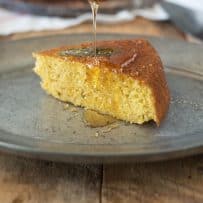 Drizzling honey onto a slice of Sage Cornbread