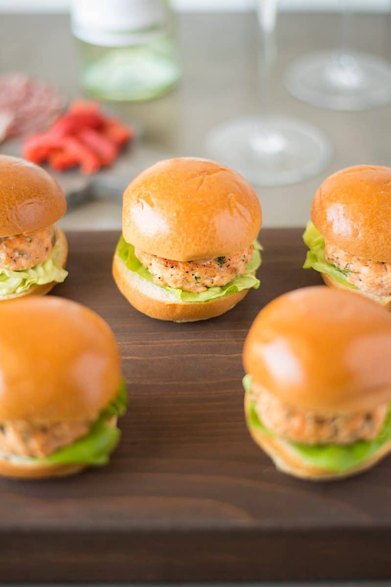 Salmon sliders with caper lemon mayonnaise are delicious, light, summery bites. Fresh salmon is mixed with chives, dill, Dijon mustard and lemon served on mini slider buns and topped with a flavorful mayonnaise.