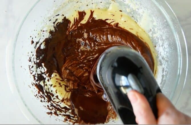Whisking melted chocolate into eggs and sugar