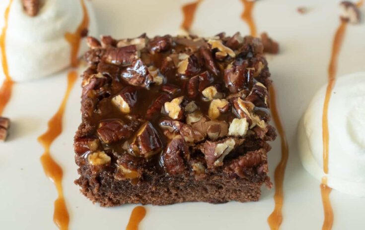 The light hitting the shiny caramel on top of the brownie with caramel drizzles and whipped cream