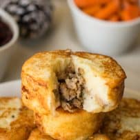 A mashed potato sausage dumpling with some removed showing the sausage stuffing inside