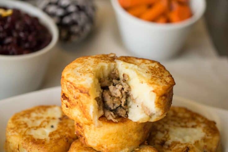 A mashed potato sausage dumpling with some removed showing the sausage stuffing inside