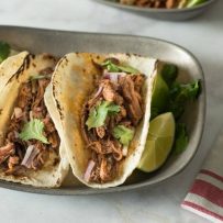 Shredded beef in a soft taco served with fresh cilantro