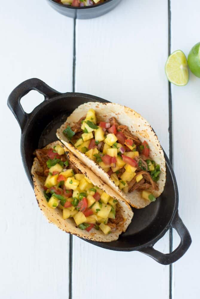 Pineapple carnitas tacos in an oval bowl viewed from overhead