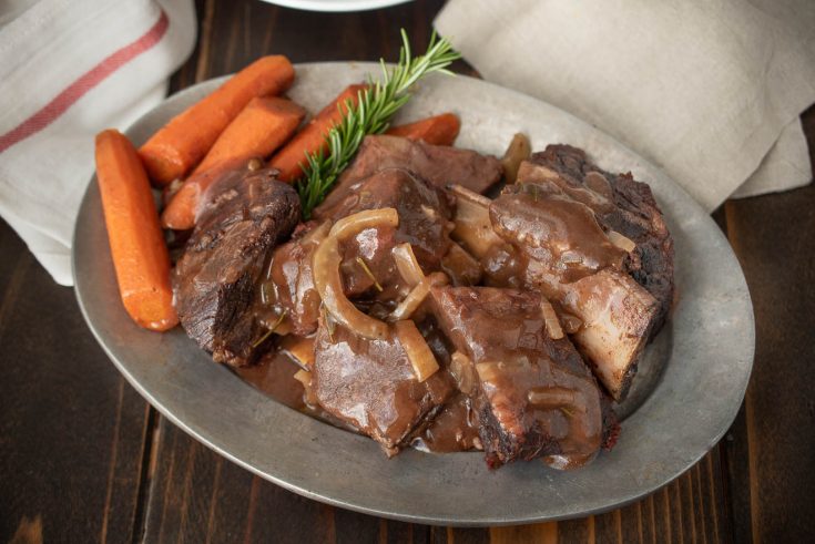 An oval platter of Tuscan short ribs with carrots