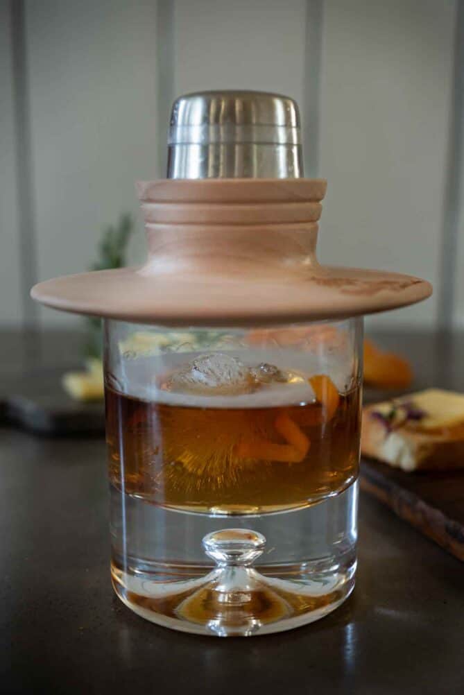 A smoke topper on a glass with smoke on top of the drink.