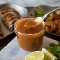 Using a spoon to spoon some sauce out of the jar