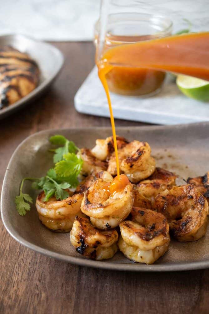 Pouring Sonoran Jalape&ntilde;o Lime Sauce  over grilled shrimp