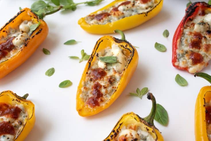 7 Sweet mini peppers on a serving board garnished with greens