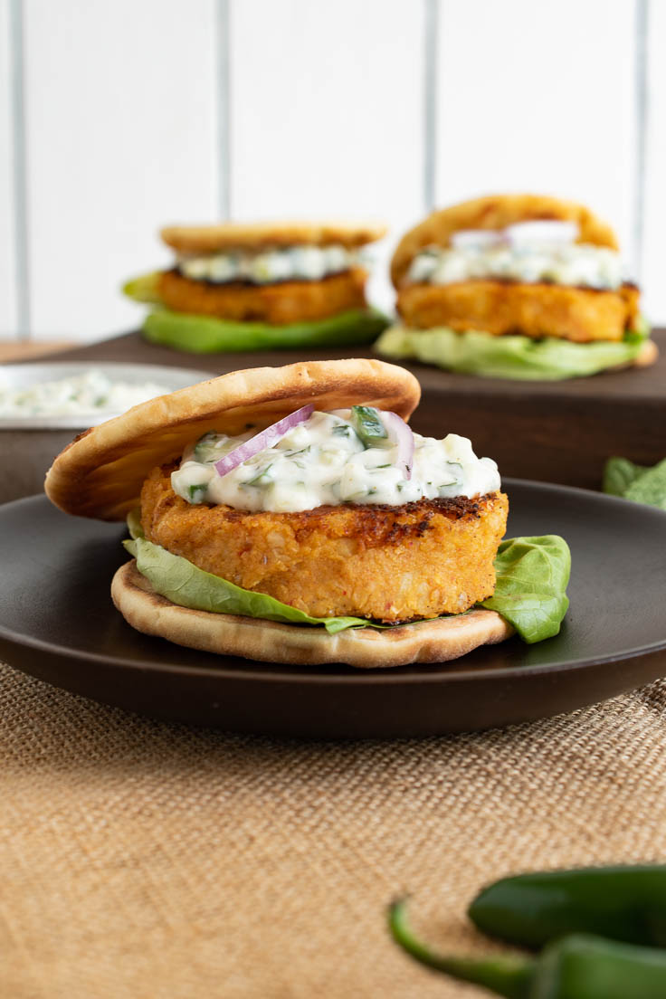 The burger from the side showing topped with cucumber raita