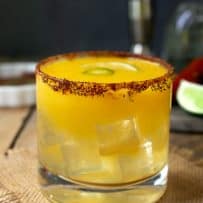 A side view showing the glass filled with ice and the chili lime salt rim