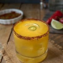 A short glass of Spicy Jalapeño Mango Margarita on a mat