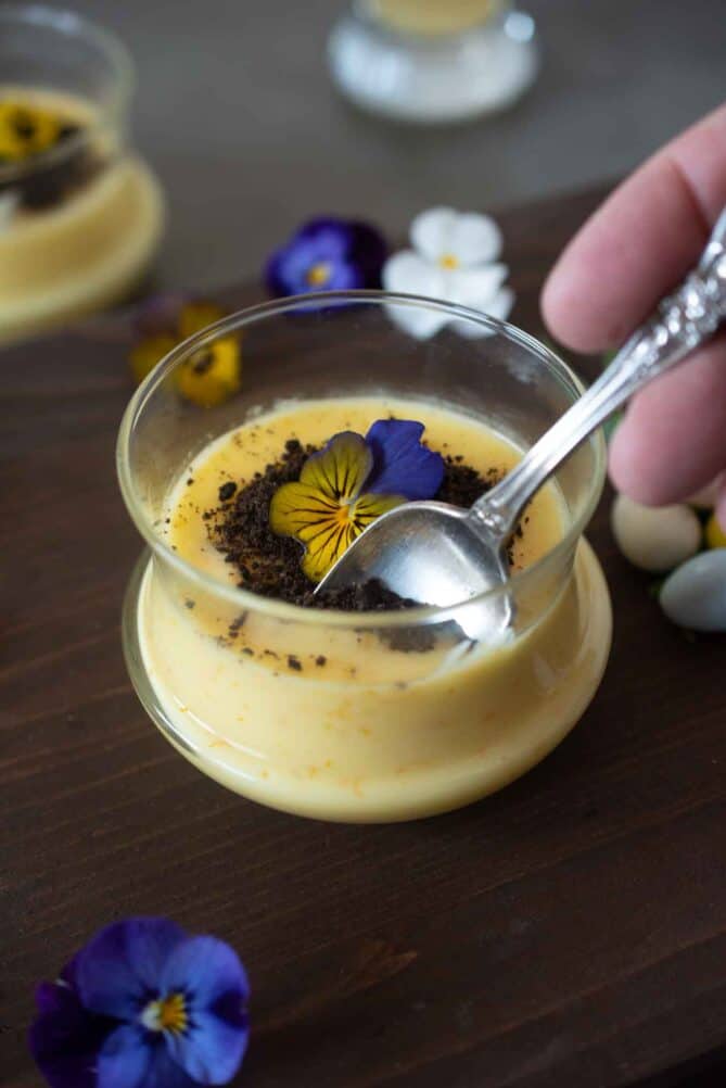 Using a spoon to serve some orange custard