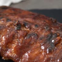 A closeup of ribs coated in a sticky Guinness sauce