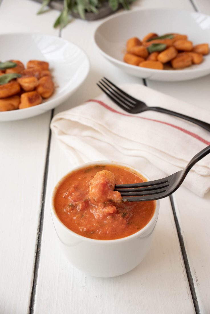 Dipping gnocchi into marinara sauce