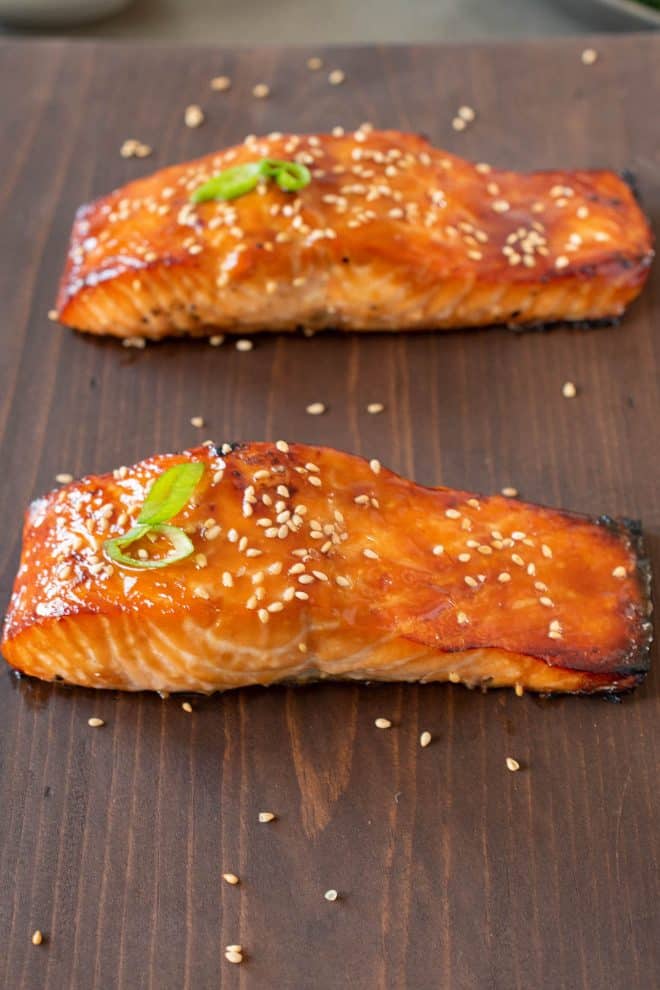 2 freshly cooked teriyaki salmon filets on a board