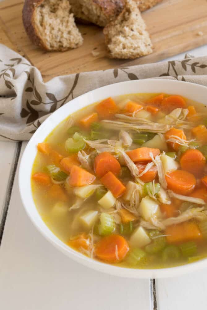 A close of chicken soup with chunky carrots and vegetables