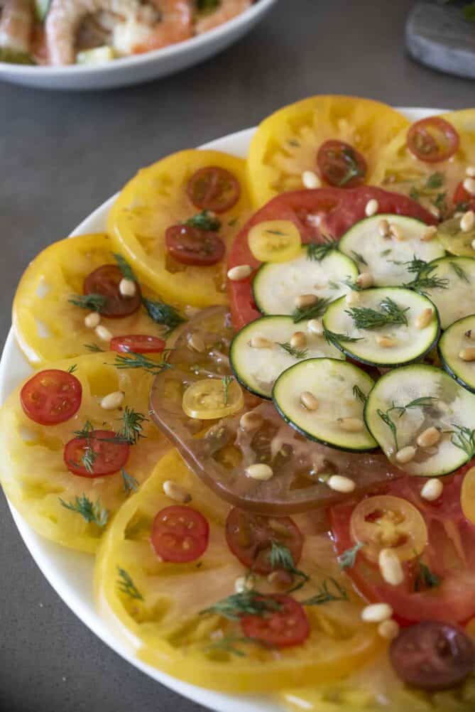 A closeup of a colorful tomato and zucchini carpaccio