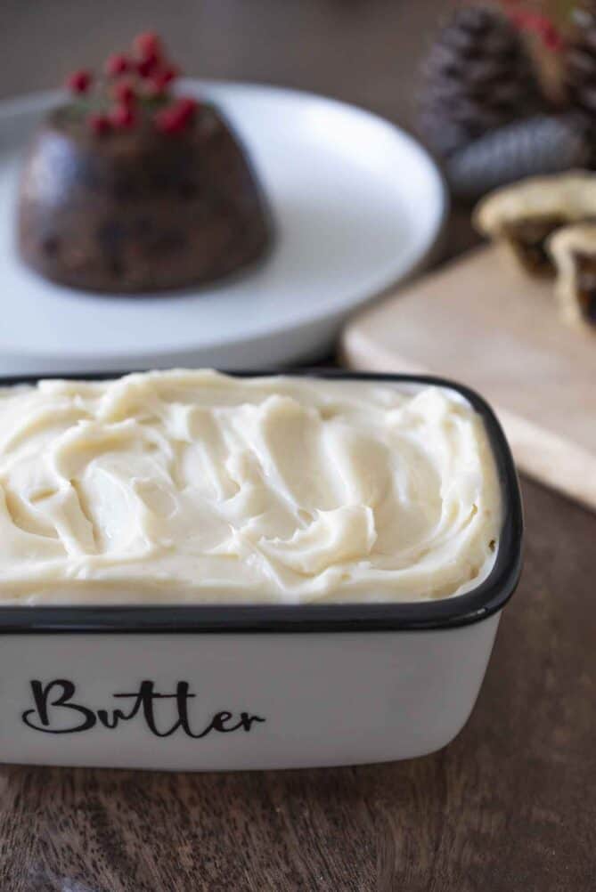 Brandy butter with a Christmas pudding in the background