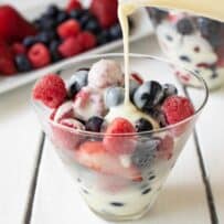 Frozen berries in a glass bowl with vanilla custard