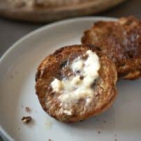 Half of a currant teacake topped with melting butter