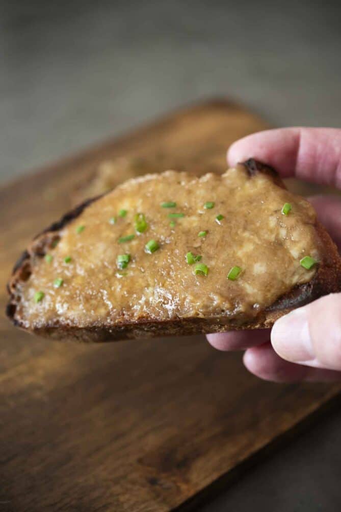 Holding a slice of open-faced grilled cheese