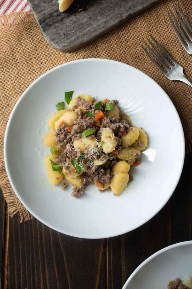 Gnocchi and white Bolognese sauce from overhead in a white pasta bowl