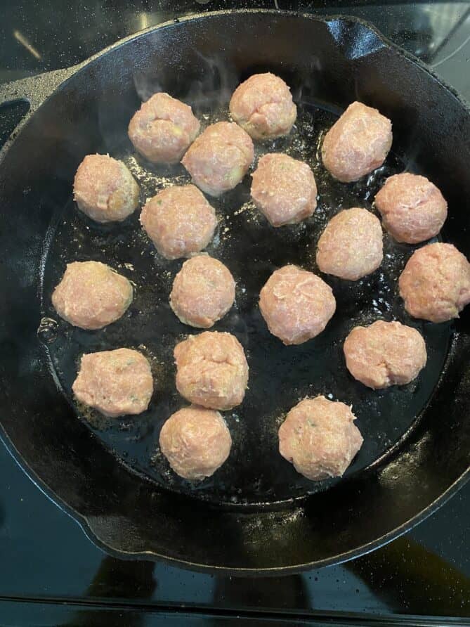 Turkey meatballs cooking in a cast iron pan