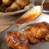 Crispy chicken pieces being drizzled with the best spicy chili sauce