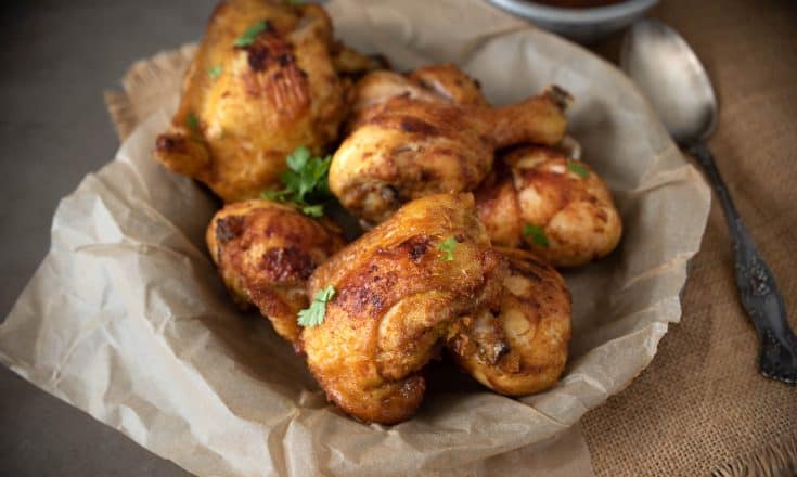 Turmeric Spiced Fried Chicken with Spicy Chili Sauce in a paper lined bowl