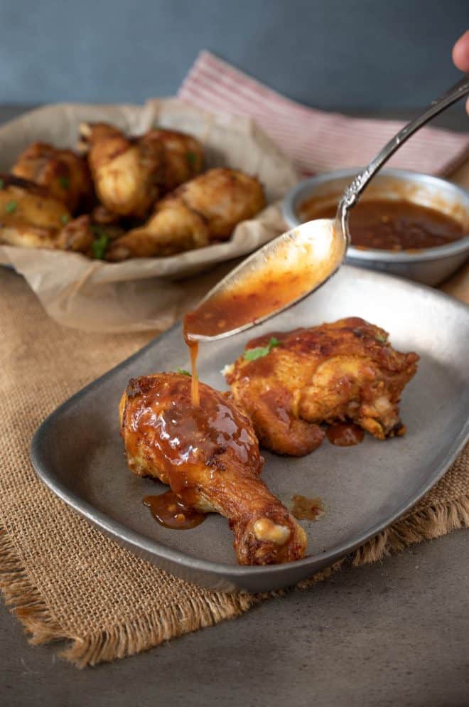 Pouring Spicy Chili Sauce over Turmeric Spiced Fried Chicken