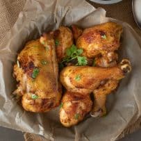 Drumsticks and thighs of Turmeric Spiced Fried Chicken garnished with cilantro