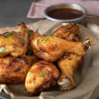 A bowl of Turmeric Spiced Fried Chicken pieces with a bowl of Spicy Chili Sauce