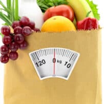 Fruit and vegetables spilling out of a bag that has a scale