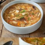 Soup in a white bowl and a spoonful of soup