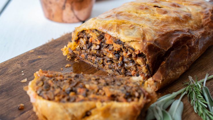 A sliced mushroom wellington showing the filling with mushroom and carrots