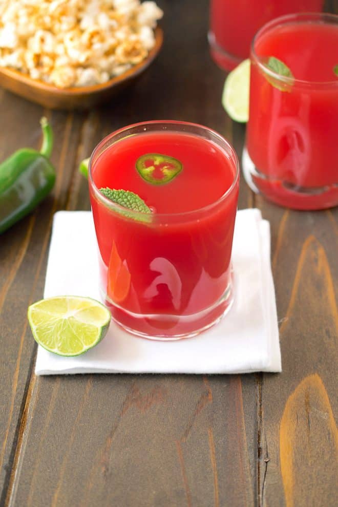 2 glasses watermelon jalape&ntilde;o agua fresca garnished with jalape&ntilde;o slices and fresh mint and a wedge of lime