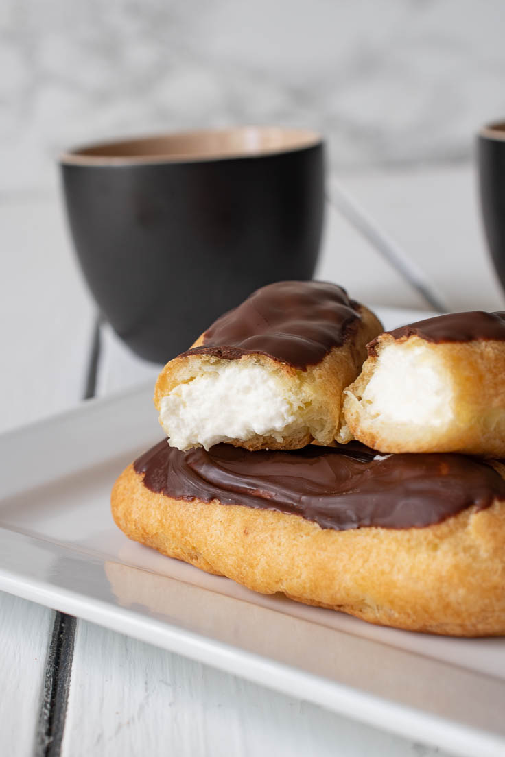 An eclair cut open showing the whipped cream filling