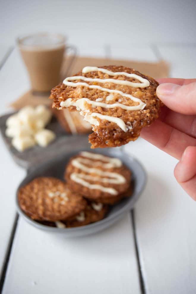 A bite take out of a white chocolate Florentine cookie