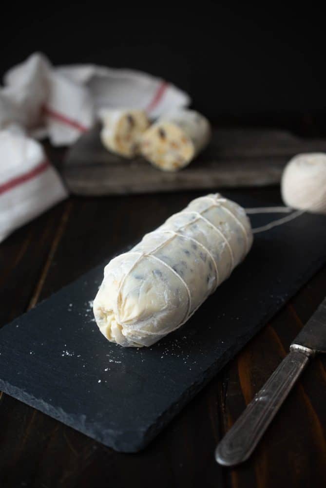 A white chocolate log on a slate board