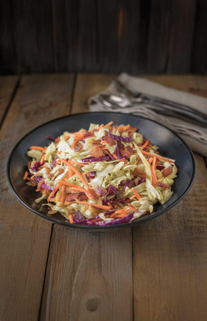 A black bowl of crispy bacon coleslaw