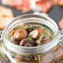 Brown mushrooms marinating in a jar