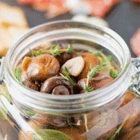 Herbs and garlic with mushrooms in a glass jar