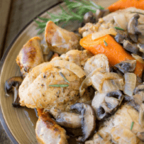 Slow cooked chicken thighs, sausages, mushrooms and carrots on a plate